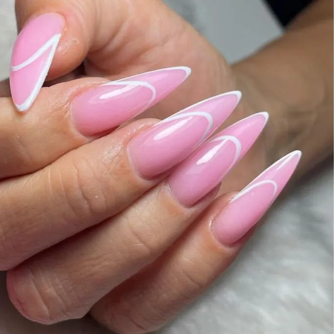 stiletto-shaped nails with a glossy, translucent pink base.