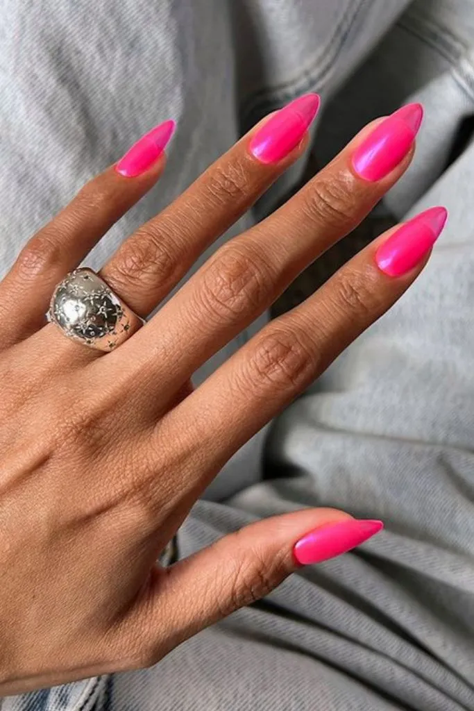 nails showcase a bold and vibrant hot pink color with a glossy finish, giving them a striking and eye-catching appearance. 