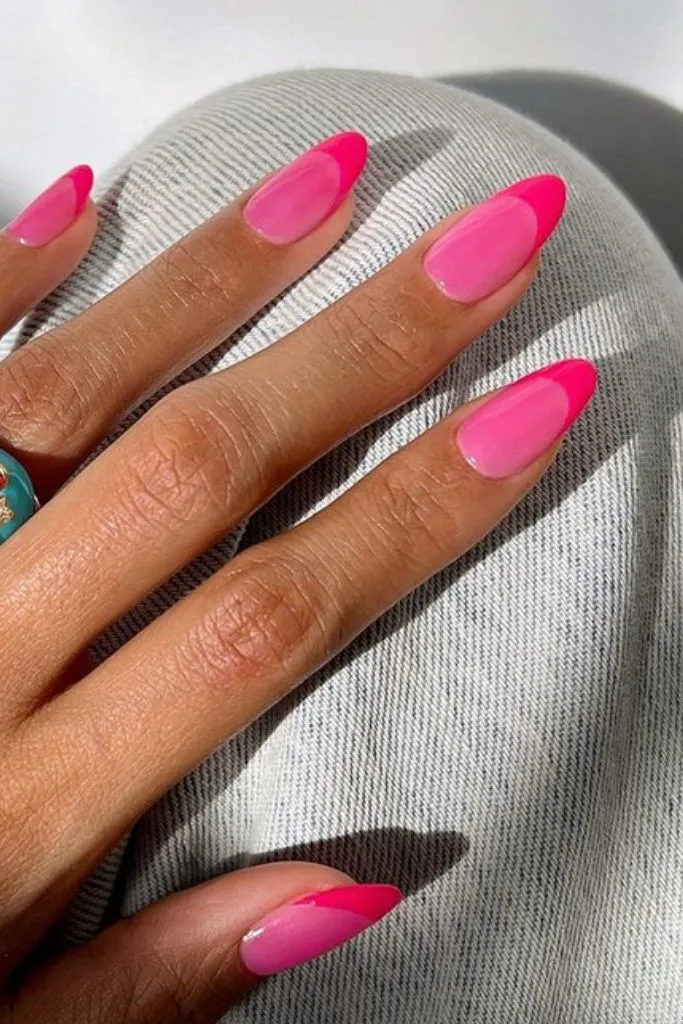 A stylish cute pink nail design featuring bold French tips in a vibrant hot pink shade on almond-shaped nails.