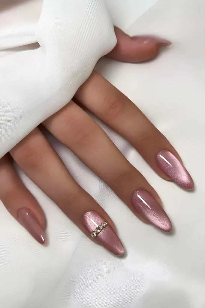  a hand with long, almond-shaped nailspainted with a pink shade